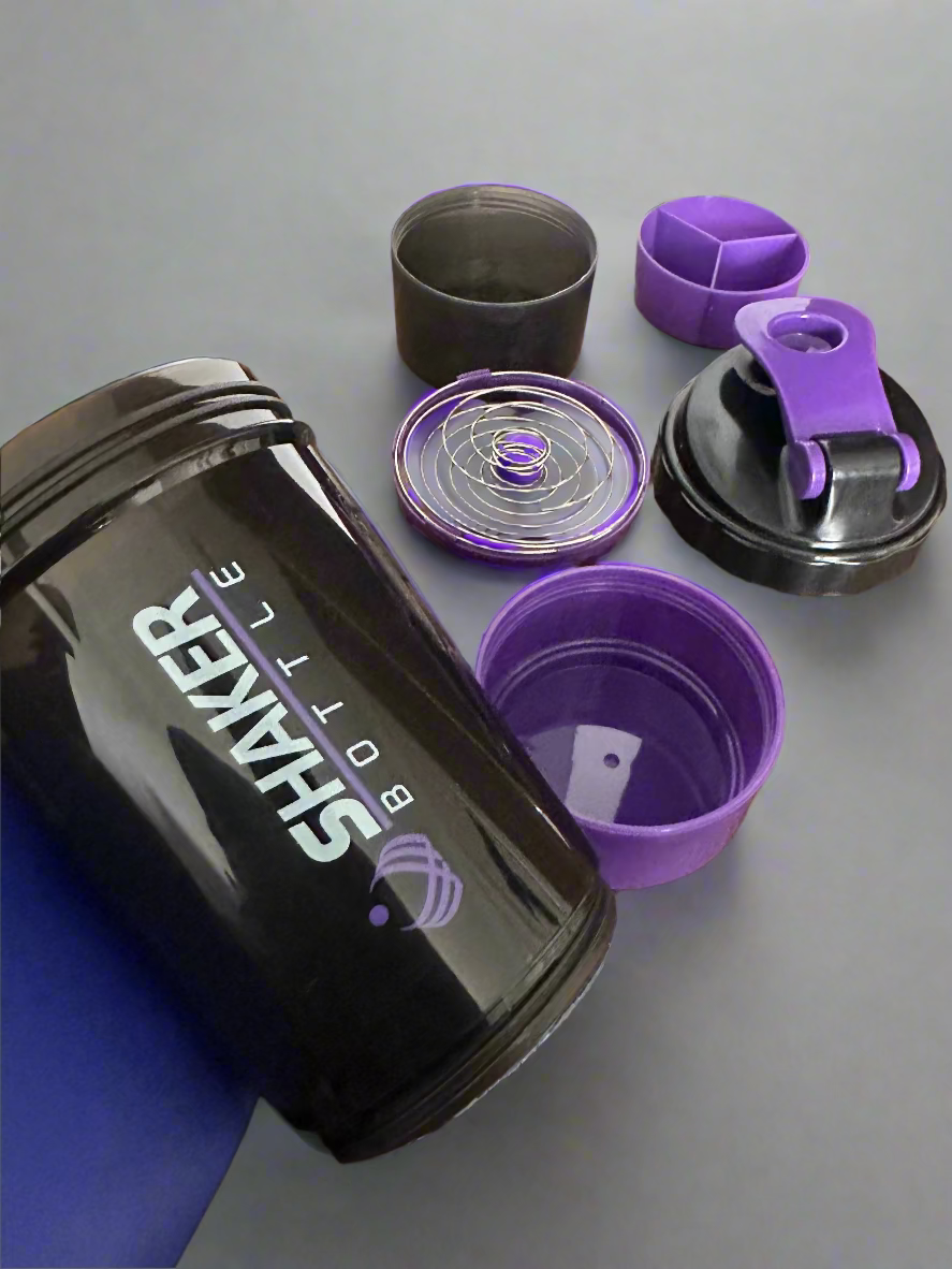 Black and purple shaker bottle with accessories on a wooden surface