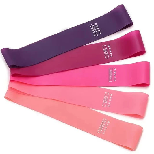 Five resistance bands in varying colors of pink, purple, and blue, labeled with resistance levels and sizes, with a carry bag.